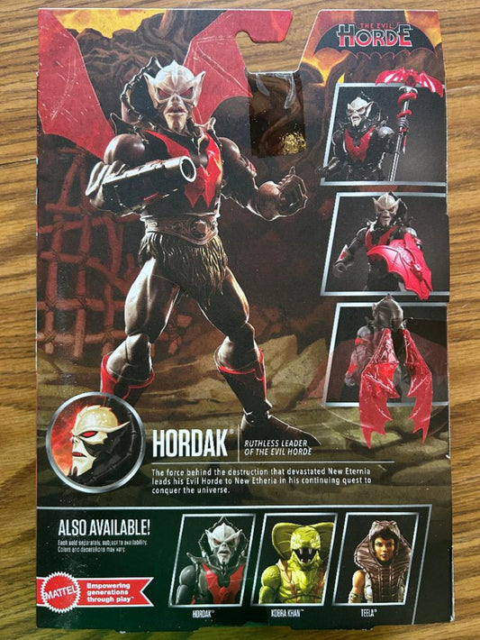Toy figure packaging featuring Hordak with additional figures on a wooden surface