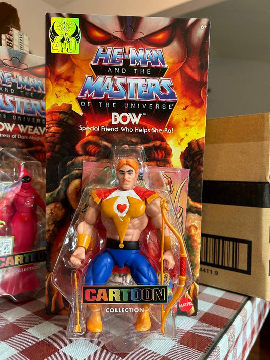 Toy figure of He-Man from 'Masters of the Universe' with packaging on a checkered tablecloth.