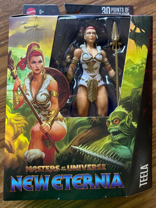 Masters of the Universe New Eternia Teela action figure in packaging on a wooden surface